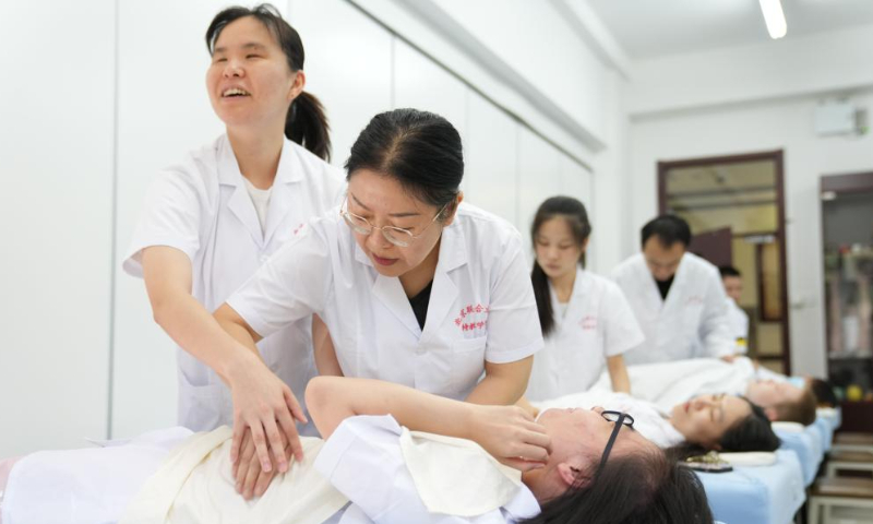 Zhang Lin (R, front) instructs a visually impaired student on massage techniques at Beijing Union University in Beijing, capital of China, Sept. 8, 2022. (Xinhua/Ju Huanzong)